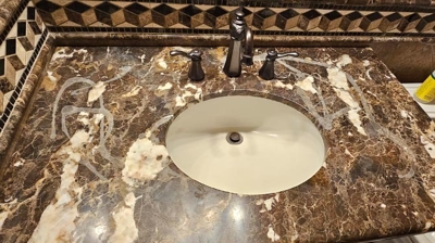 This marble vanity has been chemically damaged by improper cleaners. Photo