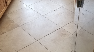 This is a BEFORE image of the kitchen floor. Notice the holes in the travertine. Photo
