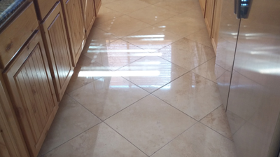 Here is an AFTER image of the kitchen floor, after we floated, honed, polished, and sealed the travertine. Photo
