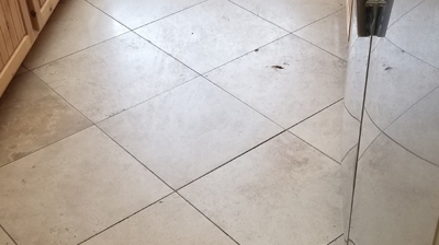 This is a BEFORE image of the kitchen floor. Notice the holes in the travertine. Photo