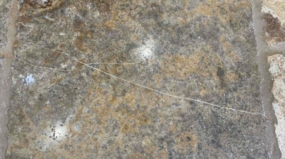 Travertine tile with crack before restoration. Photo