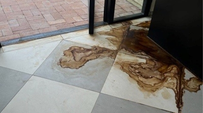 This BEFORE image shows where the planter leaked, causing a rust stain on the tile floor. Photo