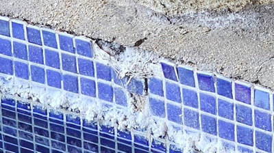 This BEFORE image shows calcium deposits, as well as broken and missing tiles. Photo