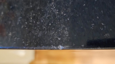 This image provides a closer look at damage along the countertop edge. Photo