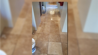 This vertical shot of the travertine floor in the hallway shows the clean floor in the top half of the image and the dirty floor Photo