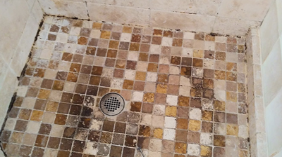 As you can see, the travertine shower pan was in very poor condition. Photo