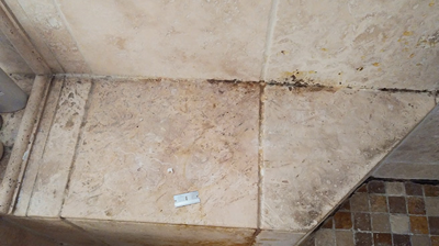 This image was taken before we cleaned the travertine shower seat. Photo