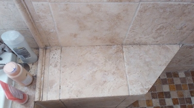 After cleaning, this travertine shower seat looks much more inviting. Photo