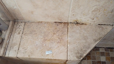 This image was taken before we cleaned the travertine shower seat. Photo