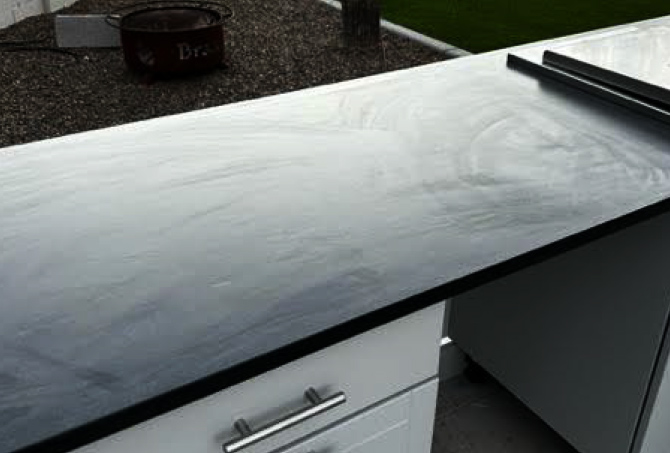 The granite countertop finish is streaked because of improper sealing.