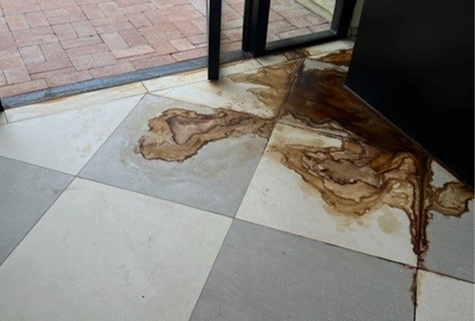 A planter leaked, causing a rust stain on the tile floor.