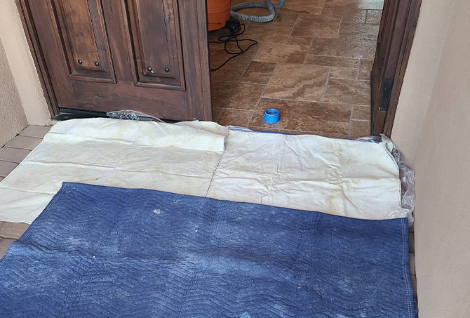 We always protect the surfaces surrounding our work area. This image shows floor cloths in an entry way.